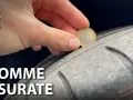Una mano inserisce una moneta da 1 euro in un pneumatico usurato, indicando che è consigliabile sostituire gli pneumatici per la sicurezza.