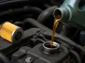 Un nuovo filtro e olio motore versato da una tanica, pronti per il cambio olio.