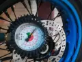 Manometro collegato alla ruota per controllare la pressione gomme moto. L'ago indica circa 2.5 bar.