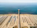 Un lungo molo si estende verso il mare calmo, con file ordinate di ombrelloni e lettini che attendono i bagnanti. Un'oasi di relax, quasi un mare vicino Firenze, dove la sabbia dorata incontra l'azzurro infinito.