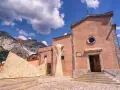 Monumento ai cavatori e chiesa a Colonnata, con le Alpi Apuane sullo sfondo. Un luogo suggestivo da scoprire, tra arte e storia.