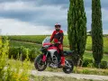 Motociclista in tenuta da gara su una Ducati, pronto per itinerari moto Toscana 1 giorno tra vigneti e cipressi.