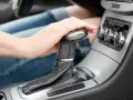 Mano su leva cambio automatico. Possibili sintomi poco olio nel cambio automatico: cambi marcia bruschi o slittamenti.