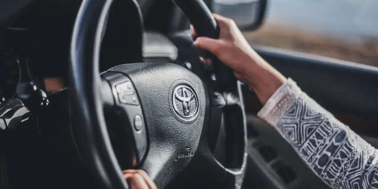 Mani sul volante Toyota, si sente che il volante trema in frenata.