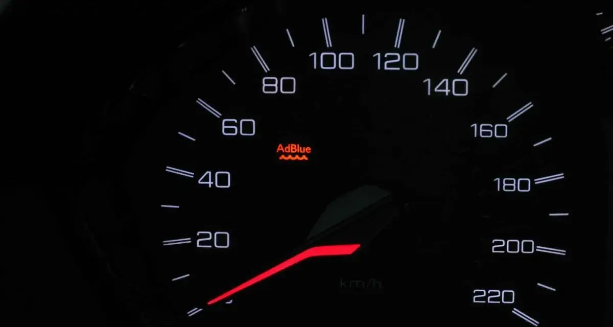 Cruscotto auto con spia AdBlue accesa, indica che il livello del liquido è basso o c'è un problema.