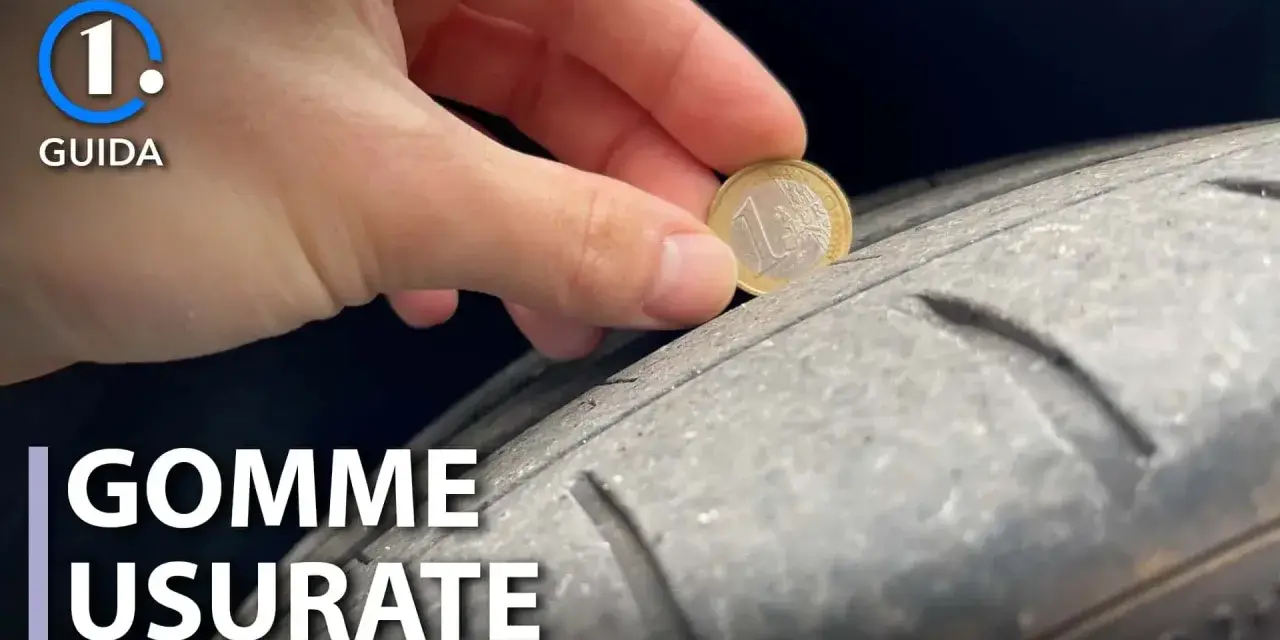 Una mano inserisce una moneta da 1 euro in un pneumatico usurato, indicando che è consigliabile sostituire gli pneumatici per la sicurezza.