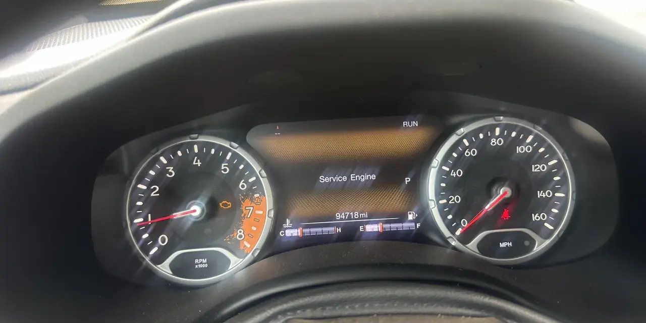 Cruscotto Jeep Renegade con spia motore accesa e messaggio "Service Engine". Chilometraggio 94718 miglia.