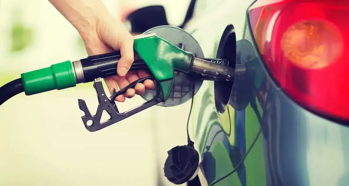 Mano che inserisce la pompa di benzina nel serbatoio. Spero di non aver messo 3 litri di benzina nel diesel!