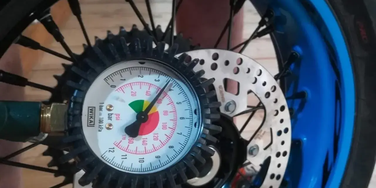 Manometro collegato alla ruota per controllare la pressione gomme moto. L'ago indica circa 2.5 bar.