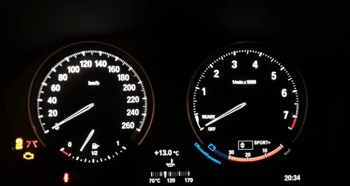 Cruscotto BMW Serie 1: spia motore accesa, tachimetro, contagiri, temperatura e ora.