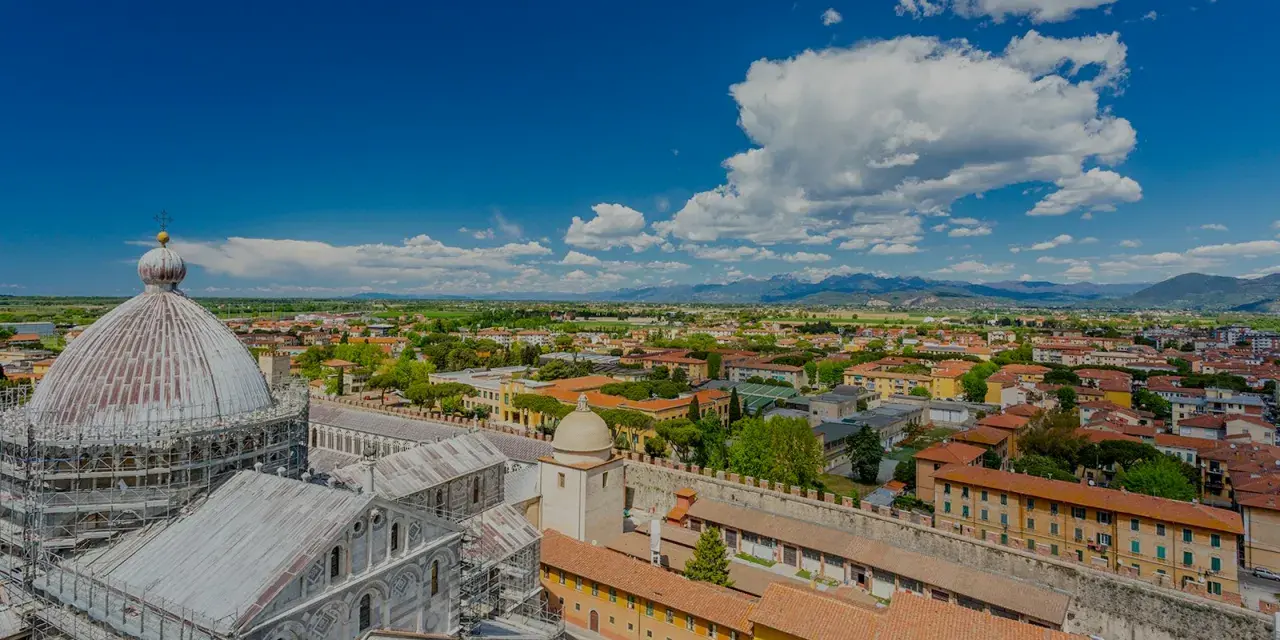 Vista dall'alto della città di Pisa, con la cupola del Duomo in primo piano. Si intravede l'interno della torre di Pisa, con la sua architettura storica.