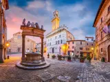 Piazza medievale con pozzo e palazzo con torre. Un assaggio di cosa vedere ad Arezzo e dintorni, tra storia e bellezza.