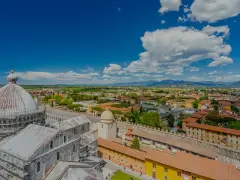 Vista dall'alto della città di Pisa, con la cupola del Duomo in primo piano. Si intravede l'interno della torre di Pisa, con la sua architettura storica.