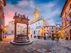 Piazza medievale con pozzo e palazzo con torre. Un assaggio di cosa vedere ad Arezzo e dintorni, tra storia e bellezza.