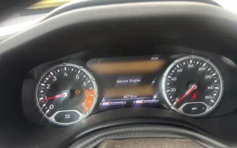 Cruscotto Jeep Renegade con spia motore accesa e messaggio "Service Engine". Chilometraggio 94718 miglia.