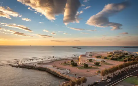 Vista dall'alto della Terrazza Mascagni al tramonto, con il mare calmo, nuvole dorate e la caratteristica pavimentazione.