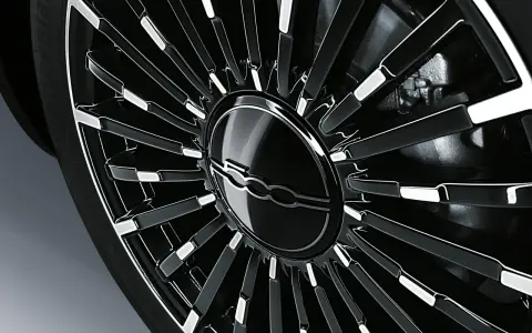 Cerchio in lega nero lucido con logo Fiat 500 al centro. La corretta pressione gomme Fiat 500 è fondamentale per la sicurezza.