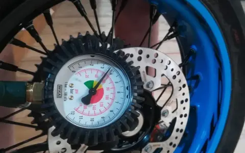 Manometro collegato alla ruota per controllare la pressione gomme moto. L'ago indica circa 2.5 bar.