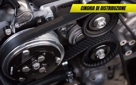 Dettaglio di una cinghia di distribuzione usurata con pulegge e tendicinghia. Sintomi di usura da non ignorare per la salute del motore.