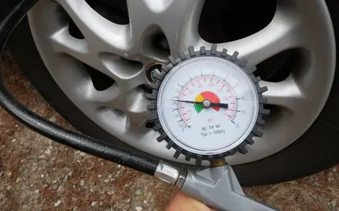 Misura la pressione delle gomme dell'auto: il manometro indica circa 2.5 bar, il valore ideale per gonfiare le gomme.