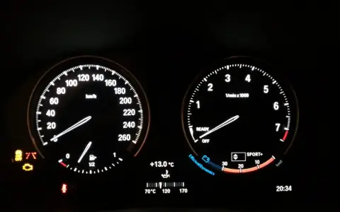 Cruscotto BMW Serie 1: spia motore accesa, tachimetro, contagiri, temperatura e ora.