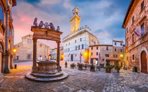 Piazza medievale con pozzo e palazzo con torre. Un assaggio di cosa vedere ad Arezzo e dintorni, tra storia e bellezza.