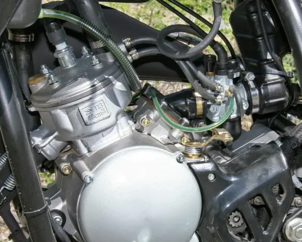 Dettaglio motore 49cc, con carburatore e candela. Potrebbe essere utile per diagnosticare sintomi motore aspira aria.