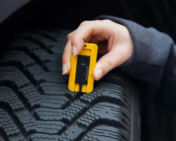 Misurazione del battistrada con calibro: un testimone di usura pneumatici per la sicurezza stradale.