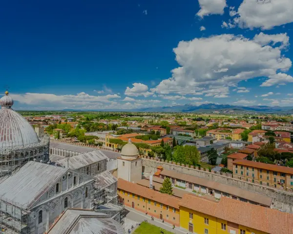 Vista dall'alto della città di Pisa, con la cupola del Duomo in primo piano. Si intravede l'interno della torre di Pisa, con la sua architettura storica.