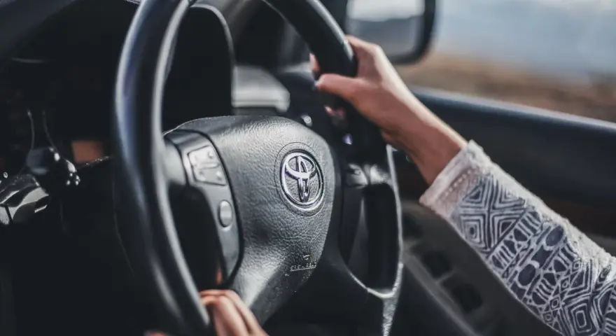 Mani sul volante Toyota, si sente che il volante trema in frenata.
