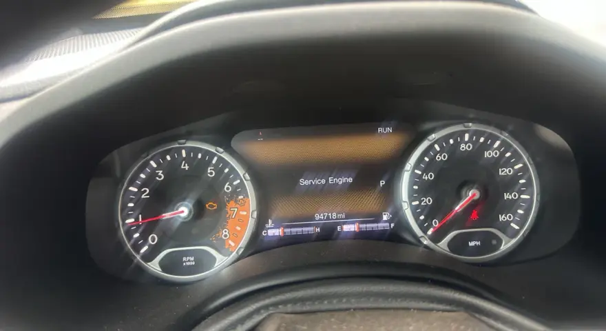 Cruscotto Jeep Renegade con spia motore accesa e messaggio "Service Engine". Chilometraggio 94718 miglia.