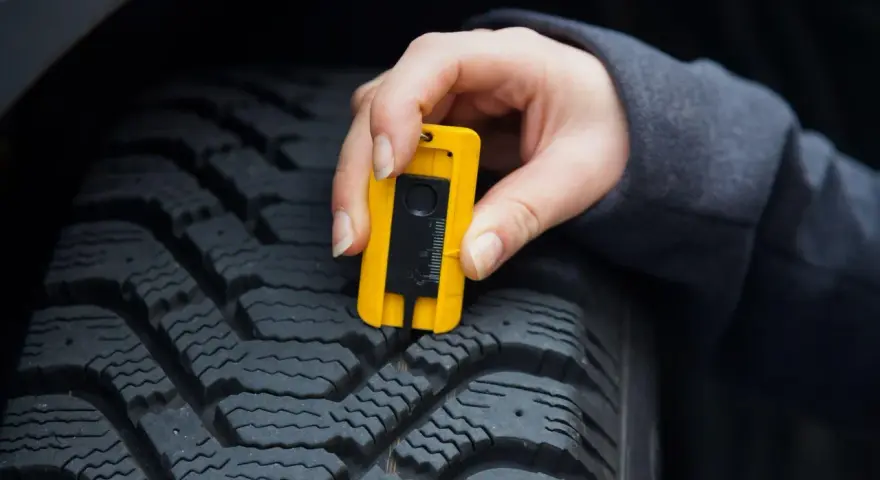 Misurazione del battistrada con calibro: un testimone di usura pneumatici per la sicurezza stradale.