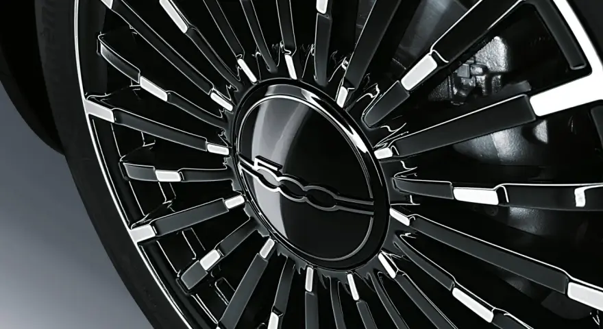 Cerchio in lega nero lucido con logo Fiat 500 al centro. La corretta pressione gomme Fiat 500 è fondamentale per la sicurezza.