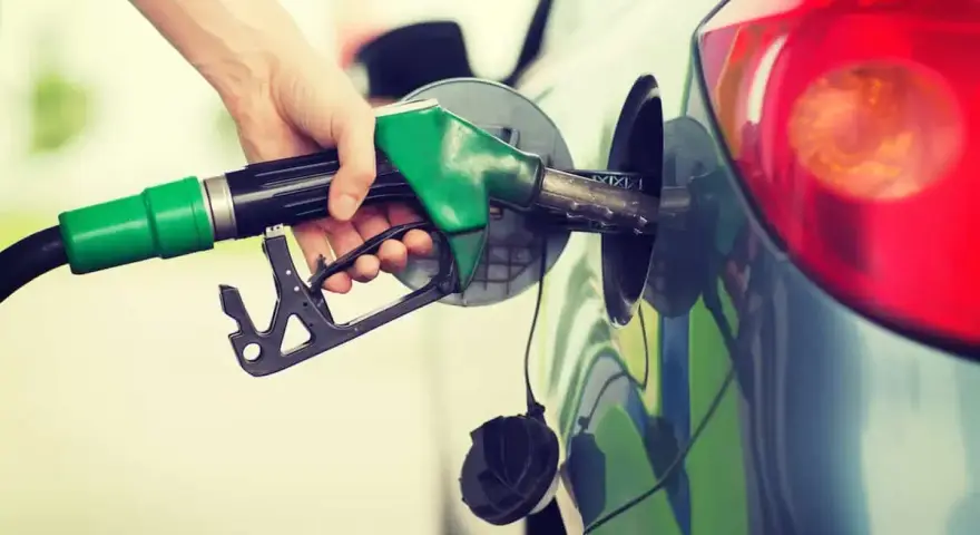 Mano che inserisce la pompa di benzina nel serbatoio. Spero di non aver messo 3 litri di benzina nel diesel!
