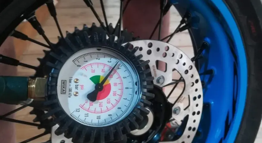 Manometro collegato alla ruota per controllare la pressione gomme moto. L'ago indica circa 2.5 bar.