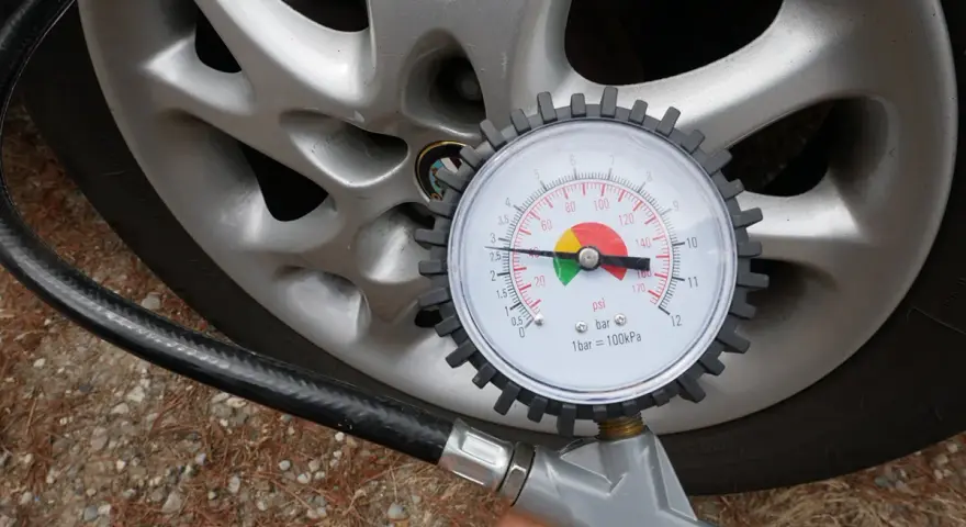 Misura la pressione delle gomme dell'auto: il manometro indica circa 2.5 bar, il valore ideale per gonfiare le gomme.