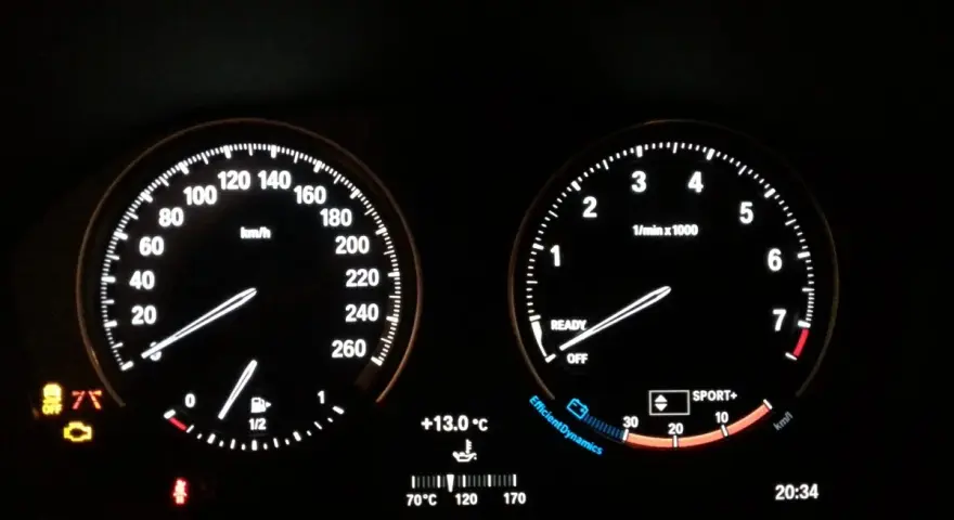 Cruscotto BMW Serie 1: spia motore accesa, tachimetro, contagiri, temperatura e ora.