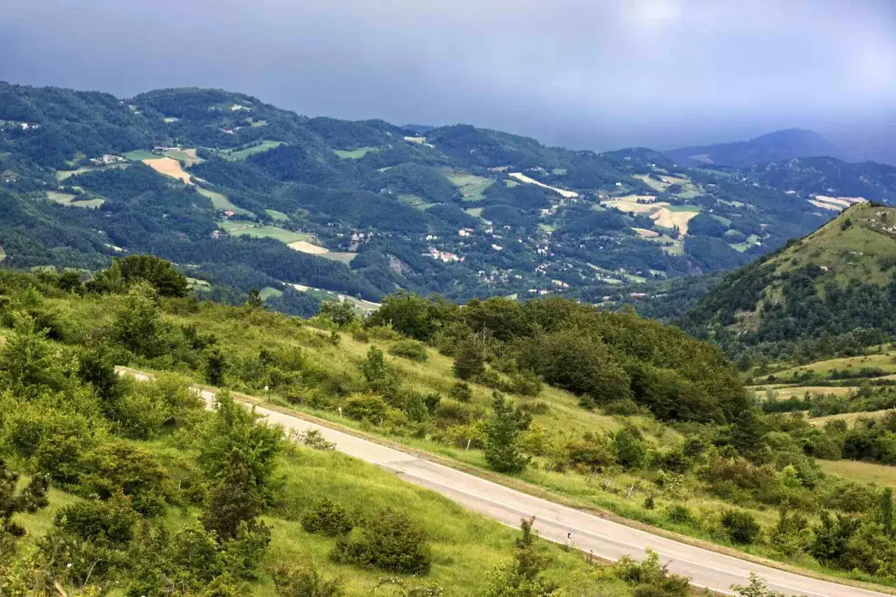 Strada panoramica sul passo della Futa, tra colline verdi e un cielo nuvoloso.