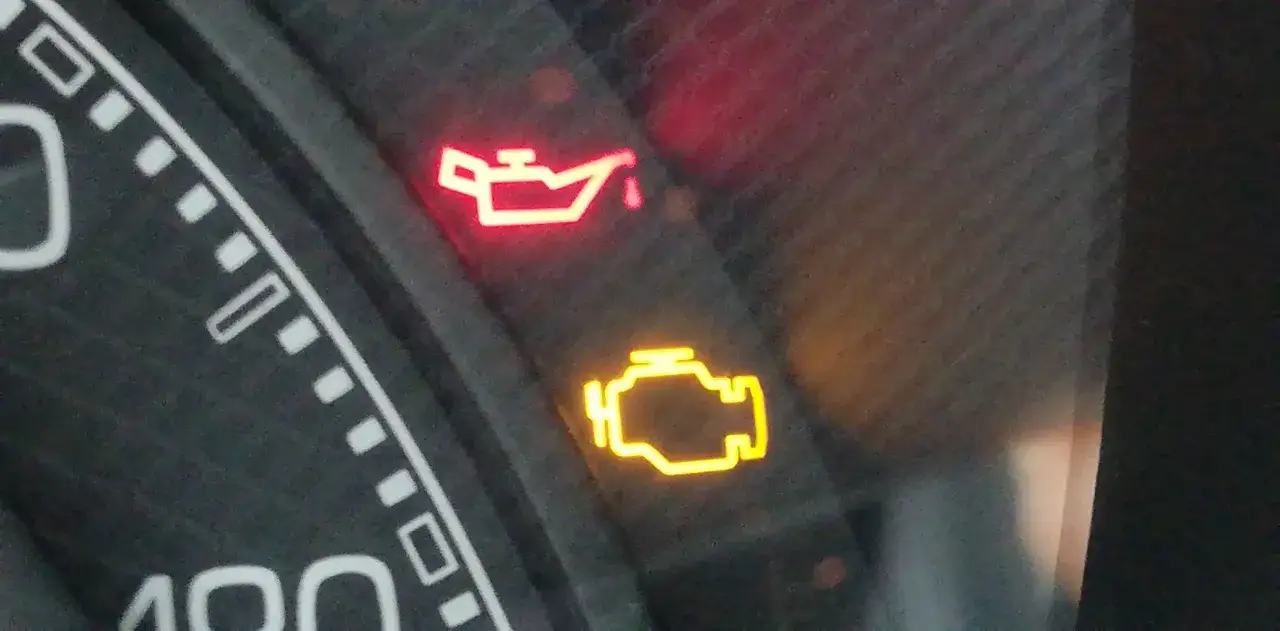 Cruscotto auto con spia pressione olio rossa accesa e spia motore gialla. Urgente controllo!