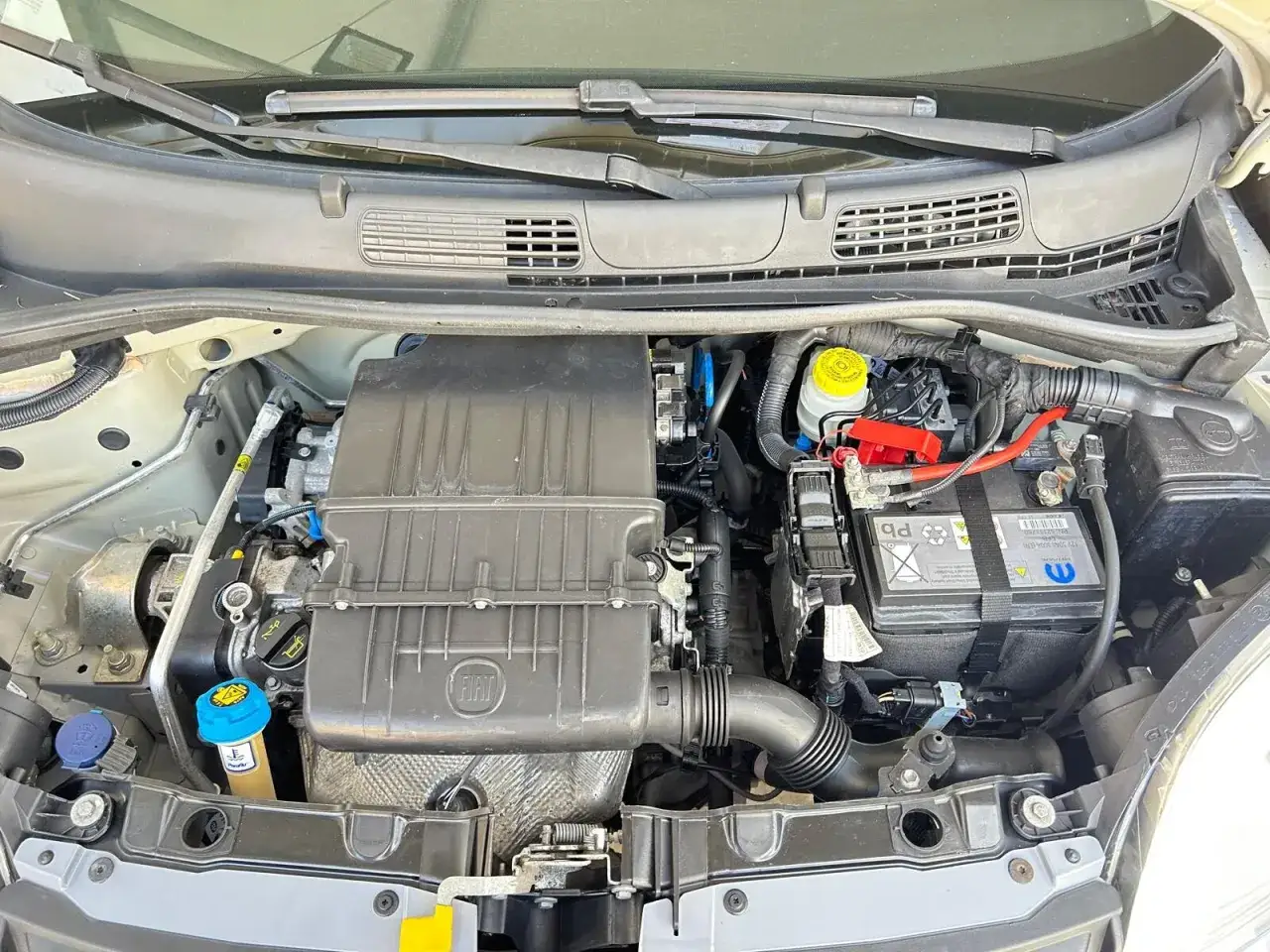 Vano motore Fiat Panda 1.2 69 cv. Si notano il motore, la batteria e vari componenti, forse per diagnosticare problemi.