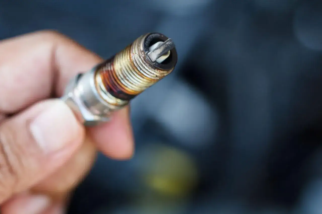 Candela auto benzina usurata, con depositi scuri. Chiediti ogni quanto cambiarle per un motore efficiente.