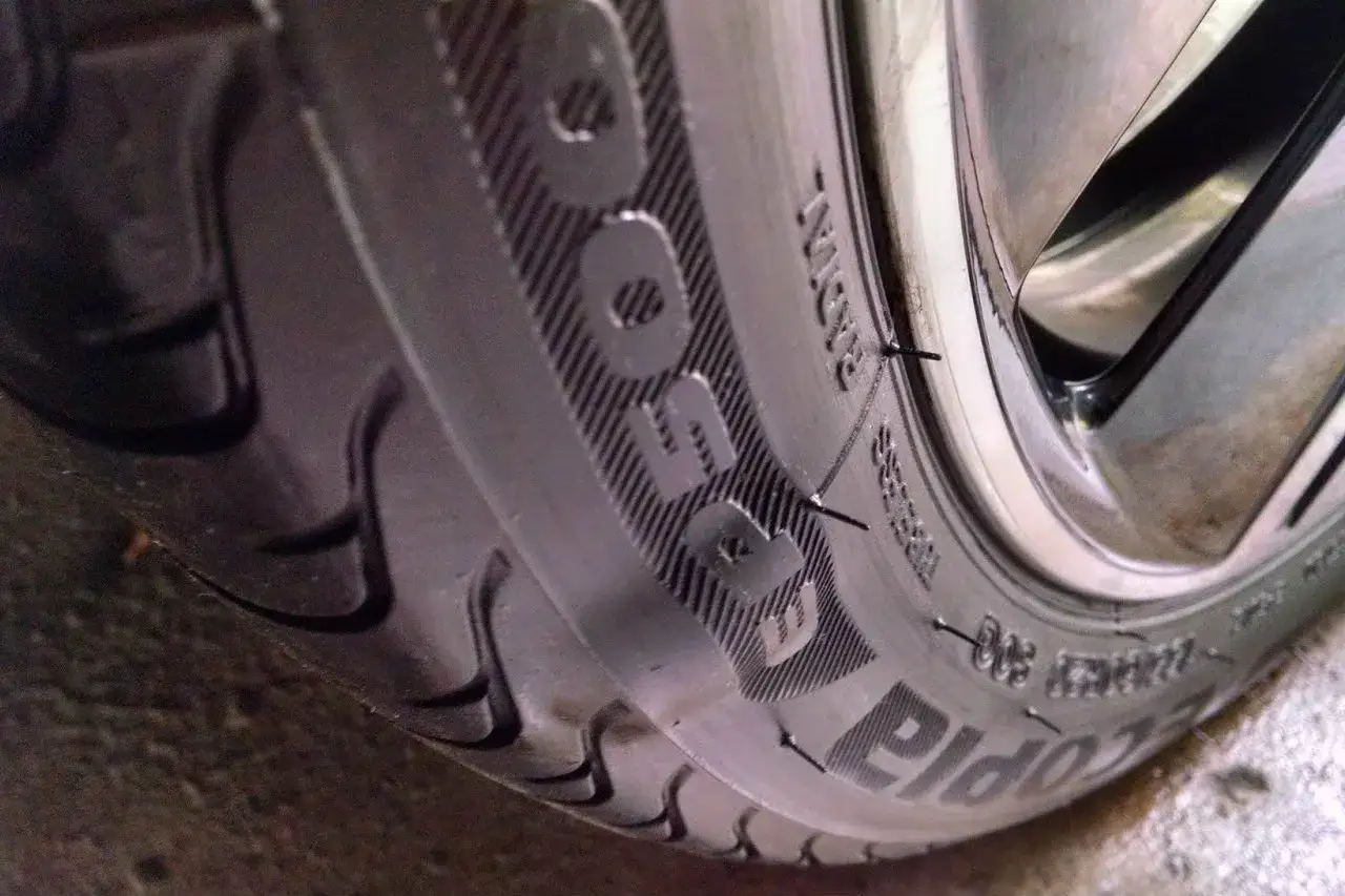 Dettaglio di un pneumatico con un'ernia visibile, forse causata da un chiodo.
