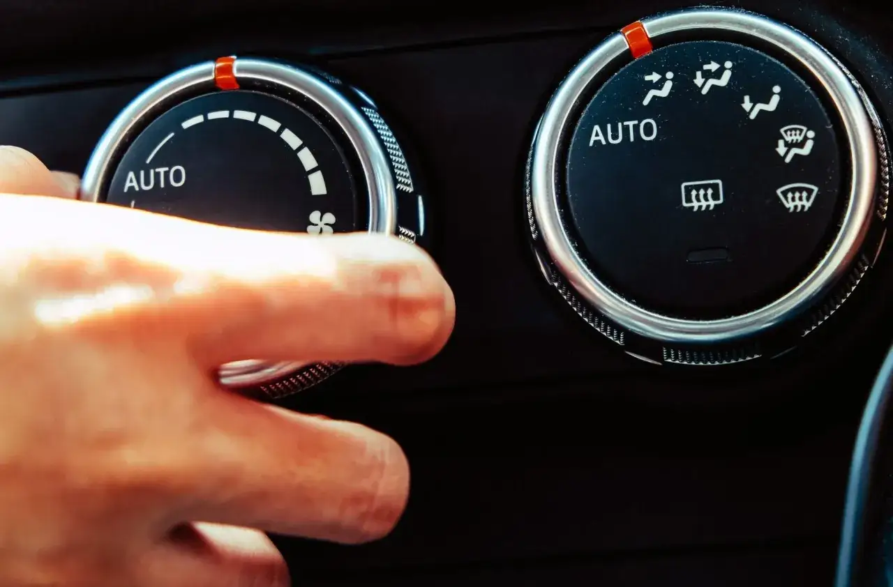 Dito, mano che regola il climatizzatore auto, attivando il simbolo ricircolo aria.