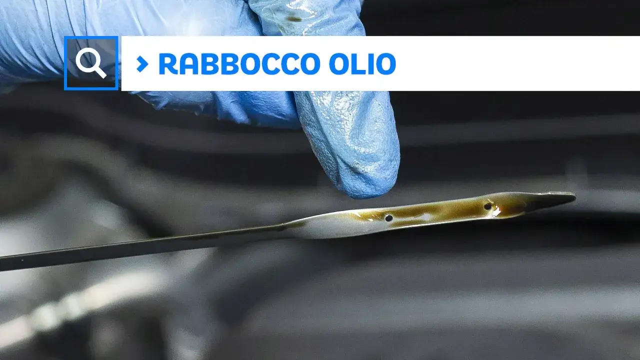 Guanto blu controlla l'astina dell'olio: il livello è troppo alto, indicando troppo olio nel motore.