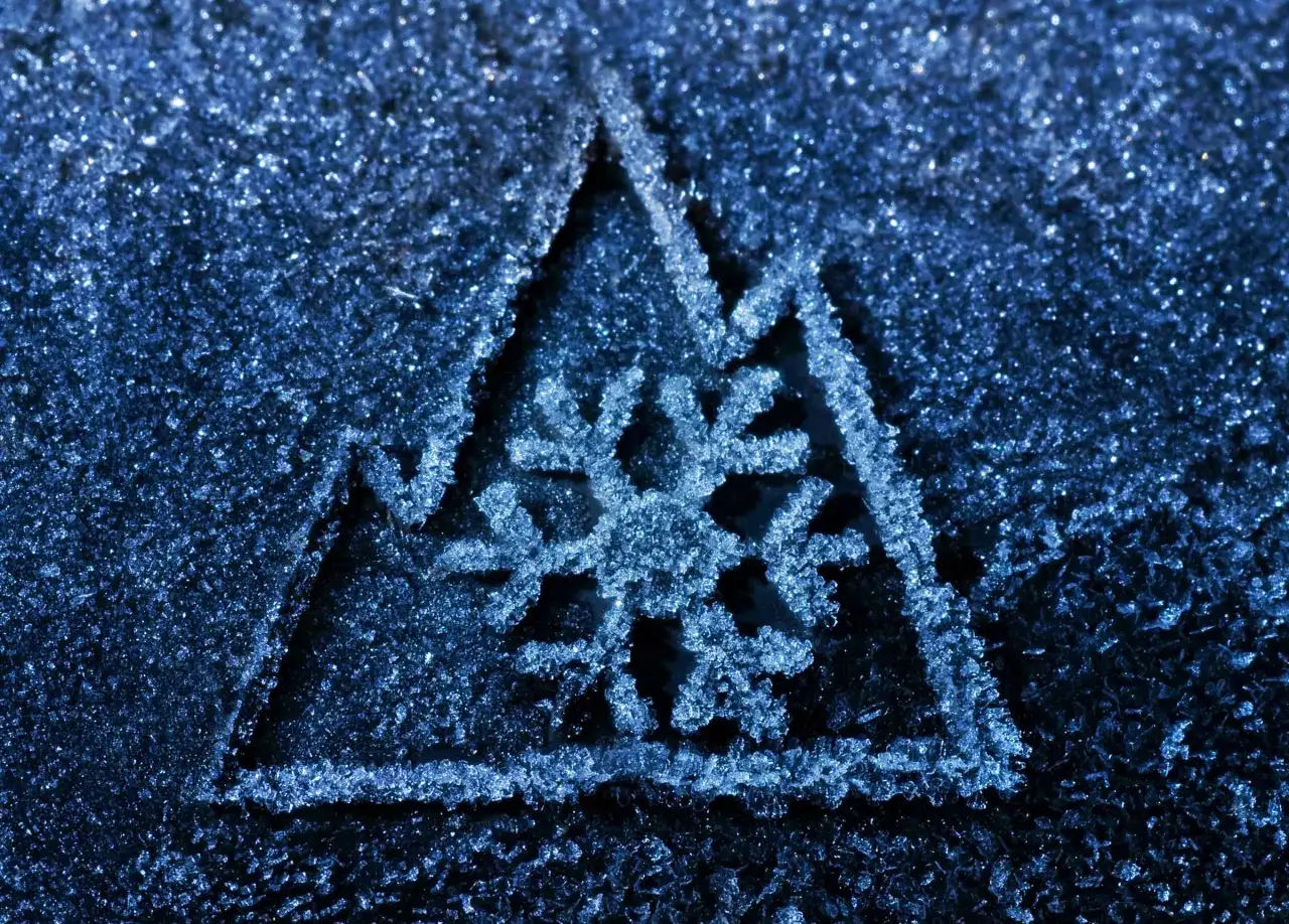 Fiocco di neve stilizzato su sfondo blu ghiacciato, un simbolo per come riconoscere gomme invernali.